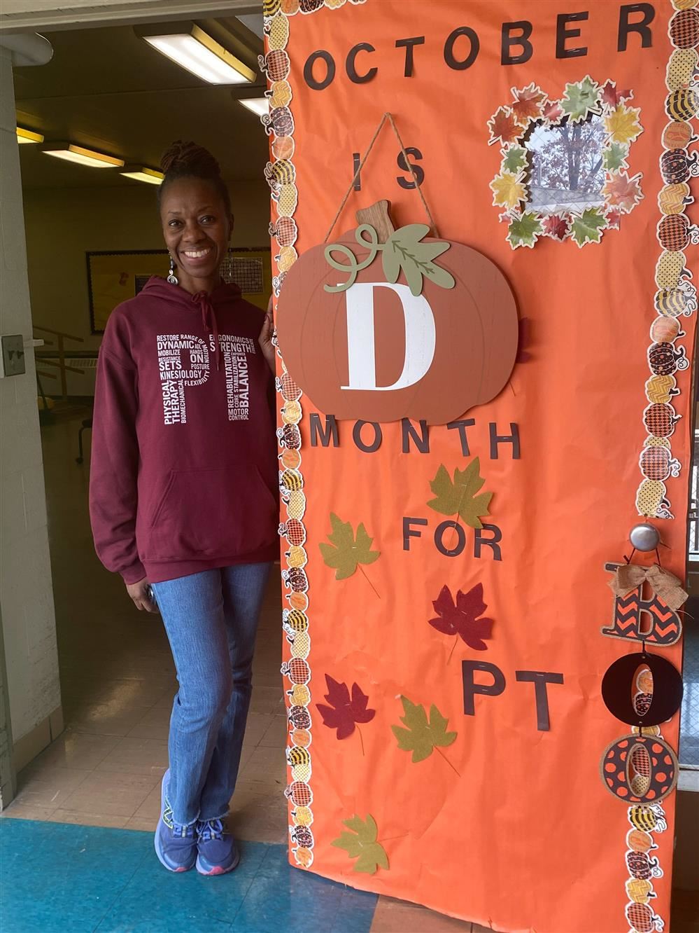  PT Led Mrs., D. Shell standing by PT month sign